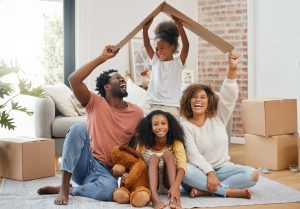Shot of a young family holding up a cardboard box to form a roof at home